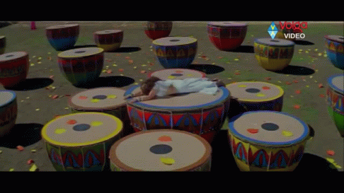a room filled with lots of drums and small white cat