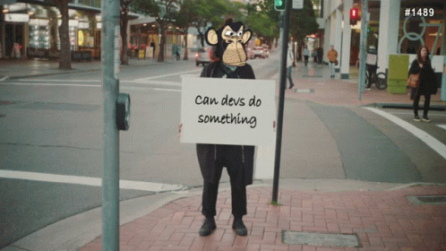 the man is standing on a sidewalk holding a sign
