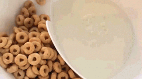 blue cereal being poured into a white bowl