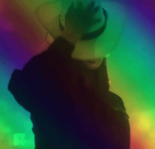 silhouetted man in white hat with multicolored backdrop