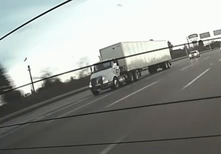 a big truck driving down the road with other trucks