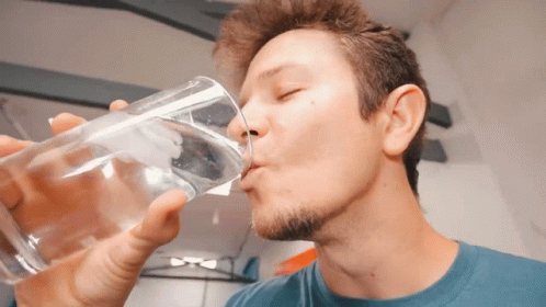 a man is drinking from a bottle of water