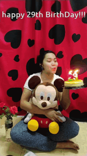 a woman sitting on the floor holding a minnie mouse