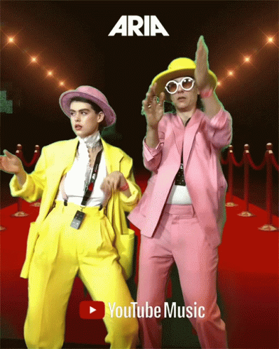 two men in matching suits and hats dance with one another