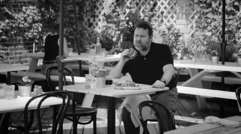 a man sitting at a restaurant eating soing