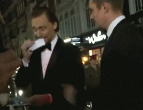 two men in tuxedos talking to each other