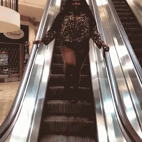 a woman on an escalator wearing black and white