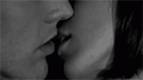 a man and woman kissing with their faces close together