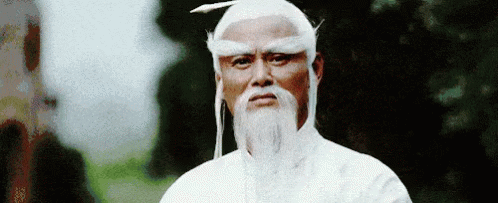 an old man with white hair and a feather on his head