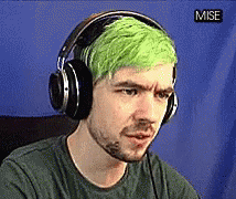 a man in headphones with a neon green hair