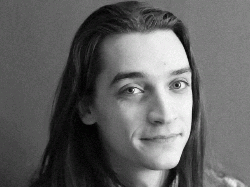 a person with long hair is smiling for a picture
