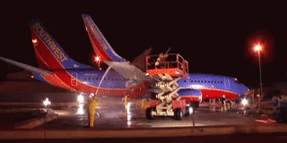 an airplane being worked on with the workers working on it
