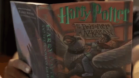 the harry potter book is on someones lap