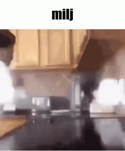 a blurry image of a man fixing a dish in a kitchen