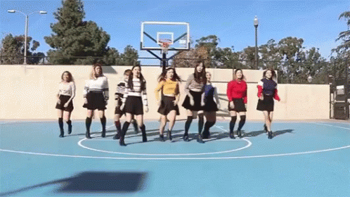 a group of women standing on a basketball court