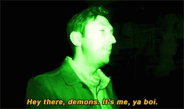 a young man stands in front of a black background, with a quote written over it that reads hey there, demons, it's me, ya doll