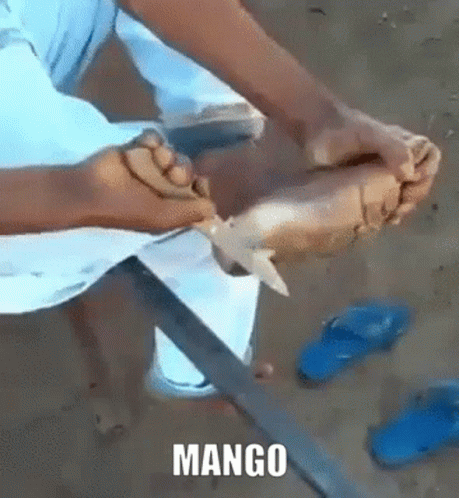a person holding a knife next to two pairs of sandals