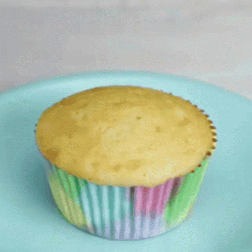 a blue cupcake is sitting on a yellow plate