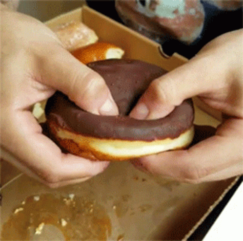 two hands that are holding doughnuts together