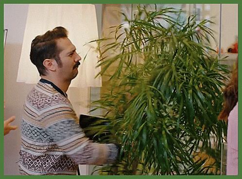 a man wearing ear buds next to a plant