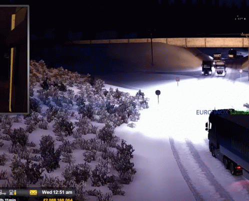 traffic is on the snow covered road, passing under an overpass