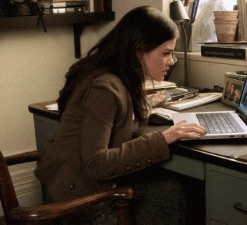 a woman sitting at a desk working on a laptop