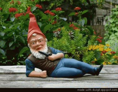 a gnome with a cigarette sitting on a wooden deck