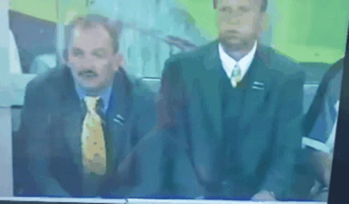 two men are sitting in suits on tv