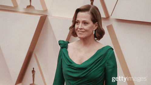 woman in green gown on the red carpet for an oscars ceremony