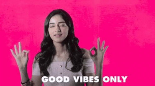 woman standing with her hands up and the caption'good vibes only '