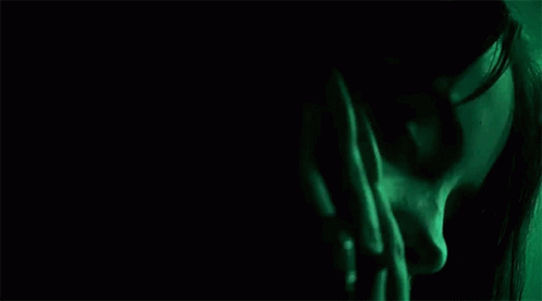 the image shows a woman in green lighting