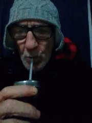 man with cold drink in mouth looking at camera
