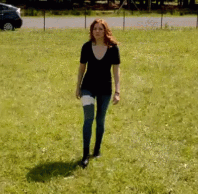 a girl is standing on the grass alone