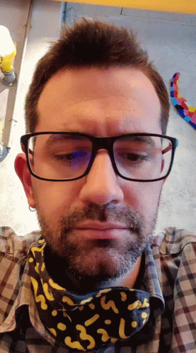a man wearing glasses looking at a camera