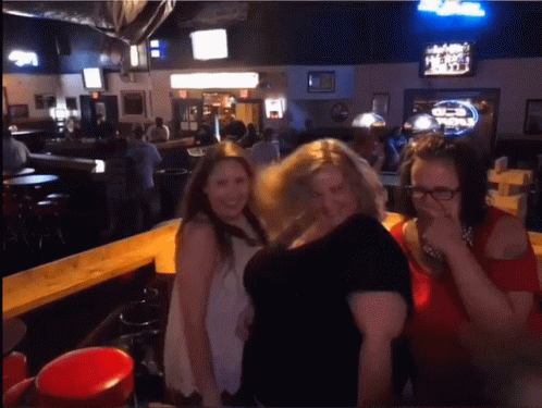 three woman standing in front of a bar