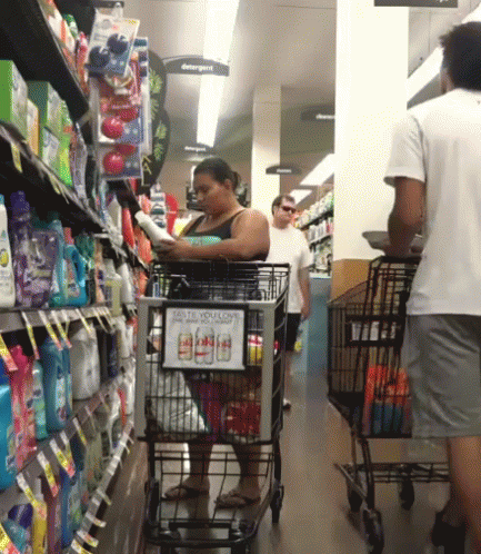 a person hing a grocery cart down a store aisle