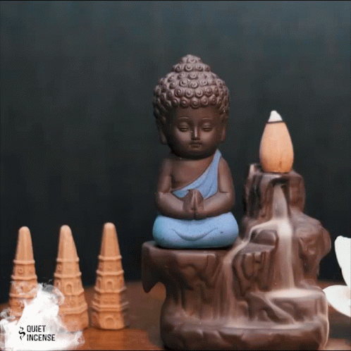 the blue buddha statue is sitting in front of cones