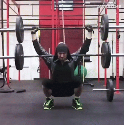 a man squatting with weights on his shoulders