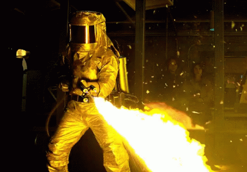 a person wearing a blue spacesuit, while holding a flame extinguisher