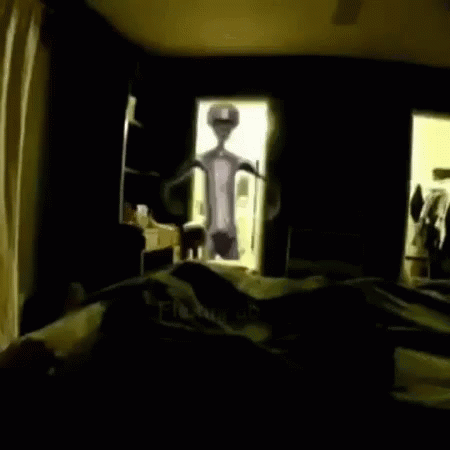 an alien in a bedroom staring in the mirror