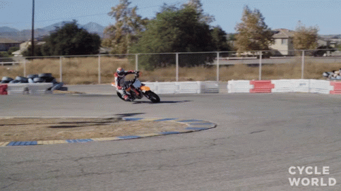 a man on a motor cycle at the end of an empty race track