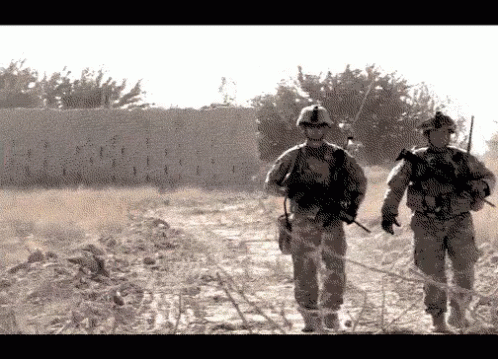 two soldiers walk together down the street