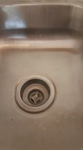 stainless steel sink with the hole for water and a stop sign