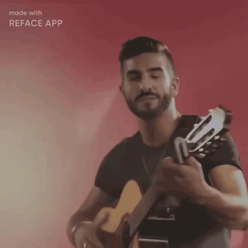 a man holding a guitar while looking at the camera