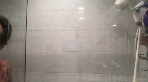 a man taking a po in front of a shower