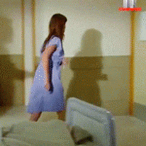 a person walking into a room with some beds