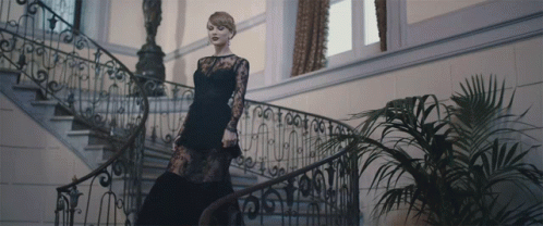 an elegant woman is walking down the stairs