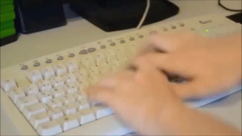 hands with gloves are typing on a white keyboard