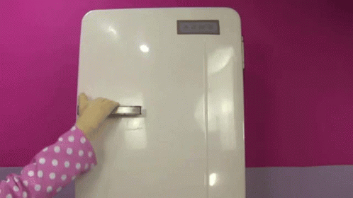 a small child is touching the back of a white refrigerator