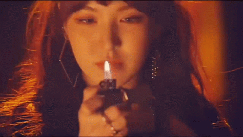 a woman holding a burning cigarette in her hand
